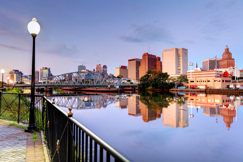 a body of water with a bridge and buildings in the background