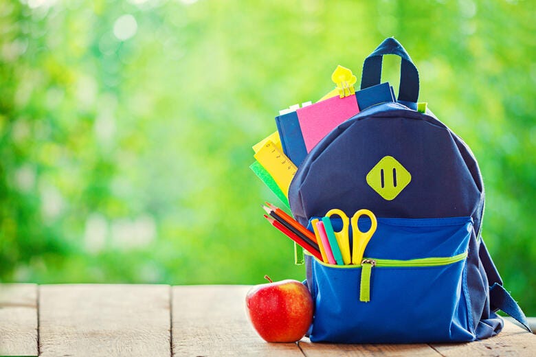 a bag with a bag and a red apple on a wood surface