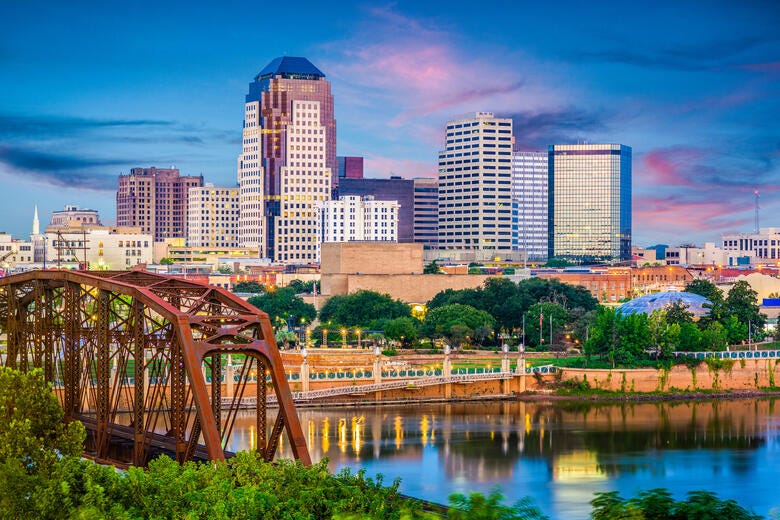 a bridge over a river with a city in the background