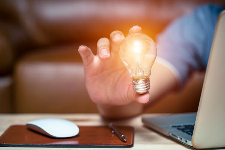 a hand holding a light bulb